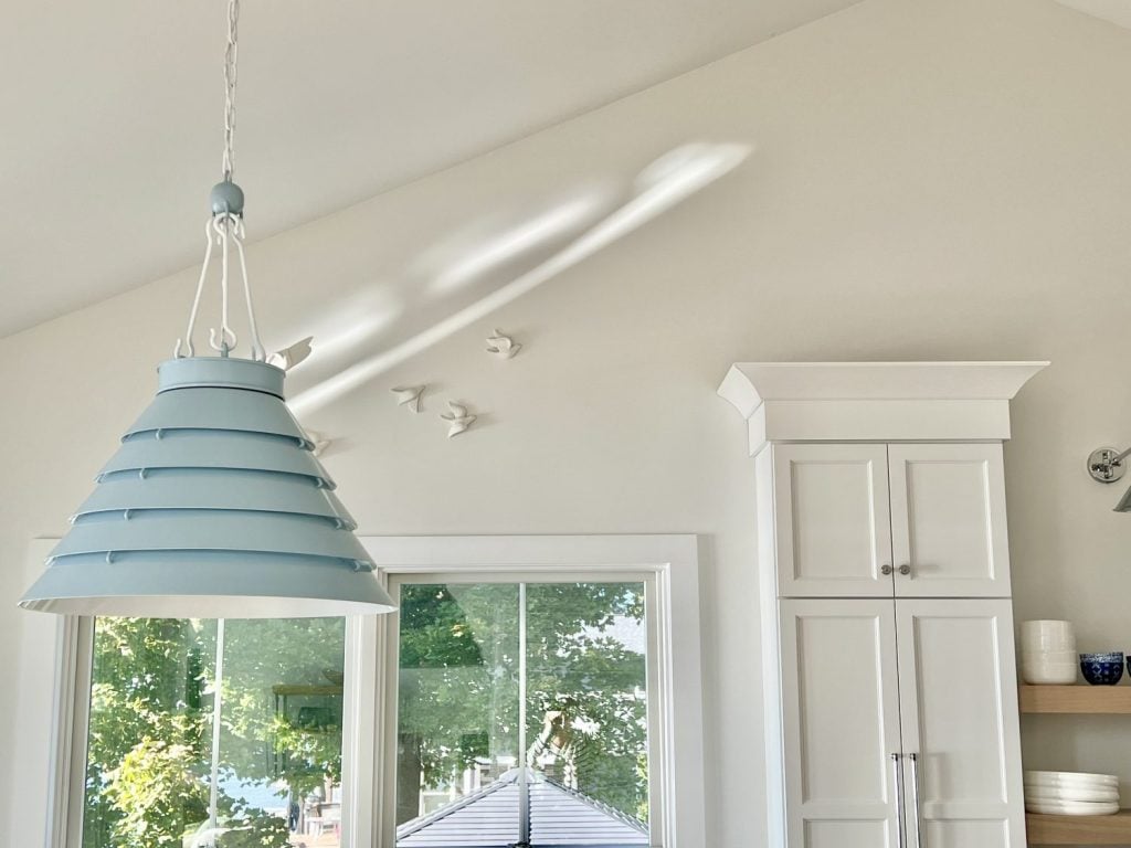 Progress Lighting Surfrider Pendant chandelier in light blue over a vaulted kitchen dining area, paired with Everlume recessed lights.