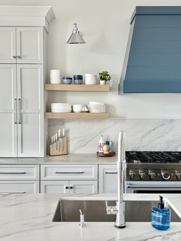 Angle view of kitchen island with Atlas Homewares Everitt Collection polished chrome cabinet hardware paired with quartz countertops