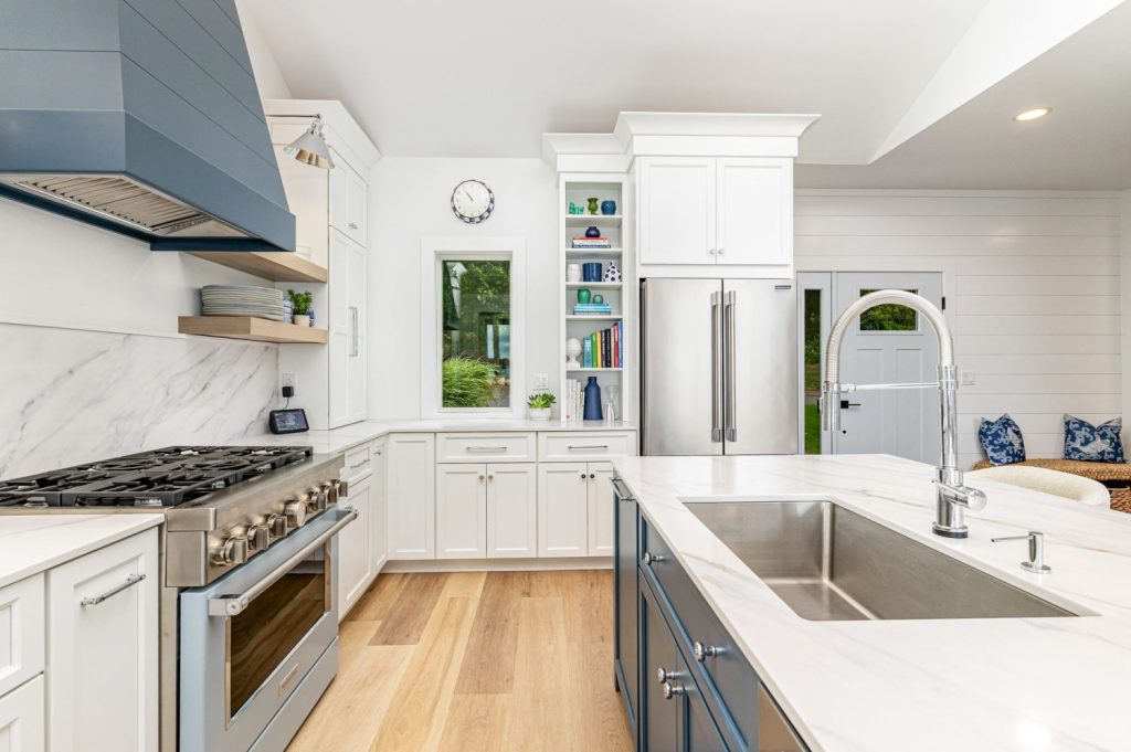 Wide view of waterfront kitchen with Atlas Homewares Everitt Collection polished chrome knobs and pulls on shaker-style cabinets