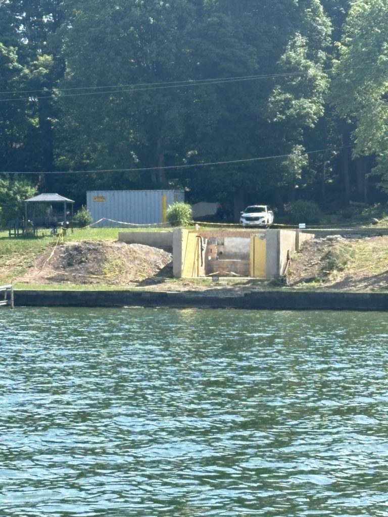 a water view of The complete demolition of a home on Cayuga Lake with just the basement foundation remaining