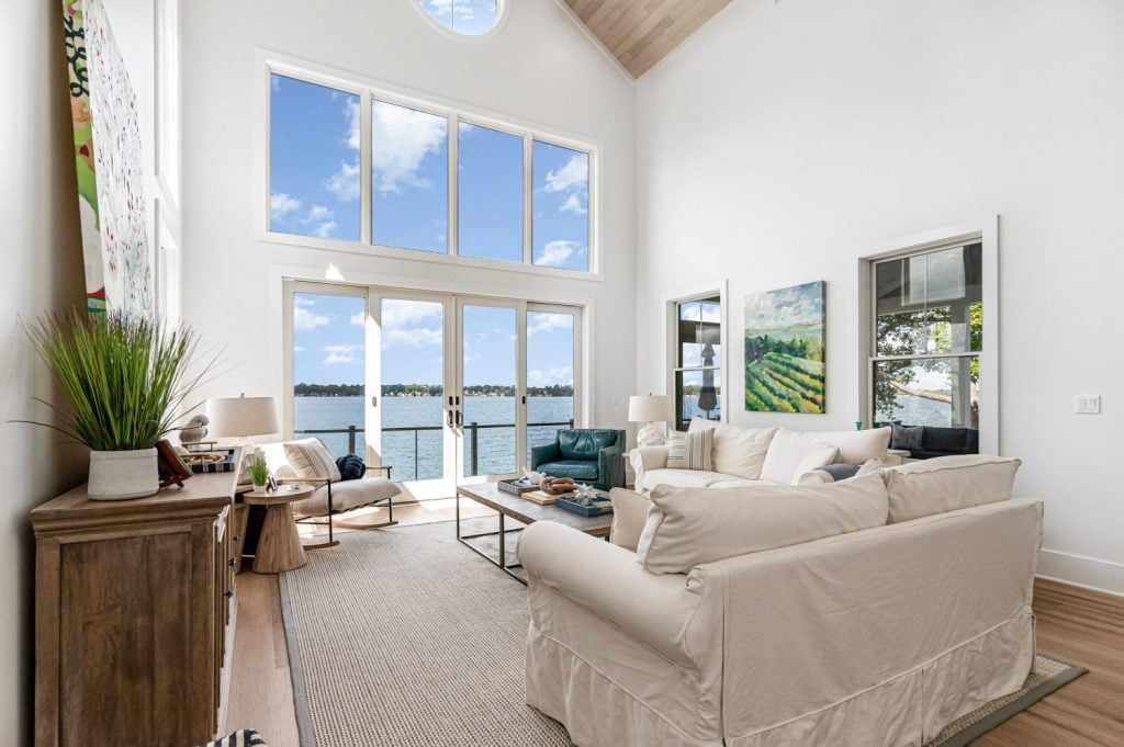 “Light oak Alabastro European Oak Ceiling by Havwoods with recessed lighting and lake view windows creating an airy coastal design.”