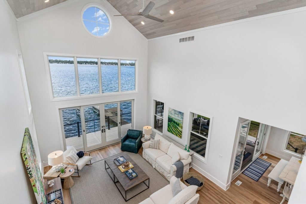 “Whitewashed Havwoods Alabastro oak planks being installed on vaulted ceiling with exposed beams and natural lake light.”