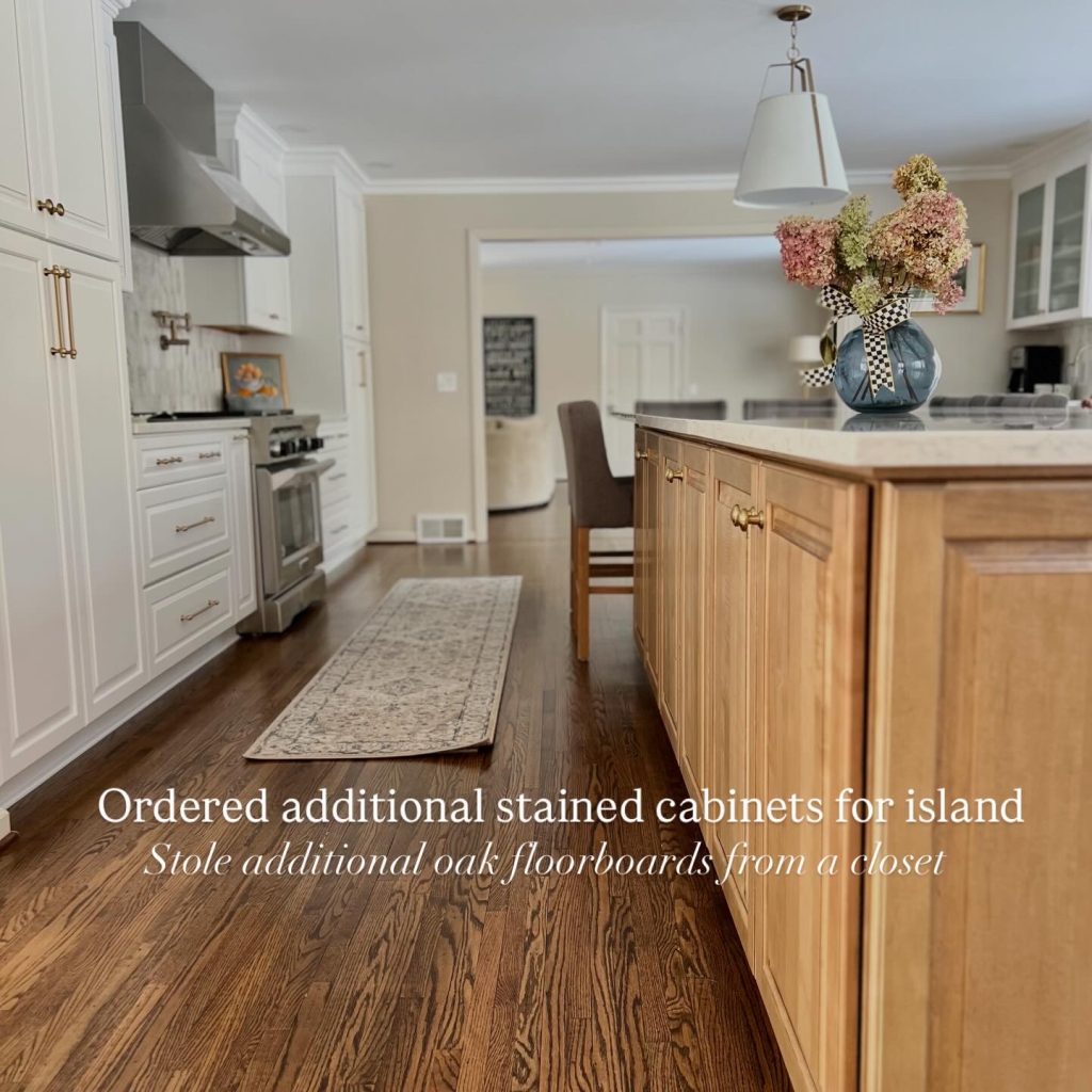 Open-concept kitchen remodel featuring a custom stained wood island with added cabinetry, white shaker perimeter cabinets, quartz countertops, stainless steel range and hood, and seamlessly matched refinished oak hardwood floors for a cohesive luxury kitchen design.