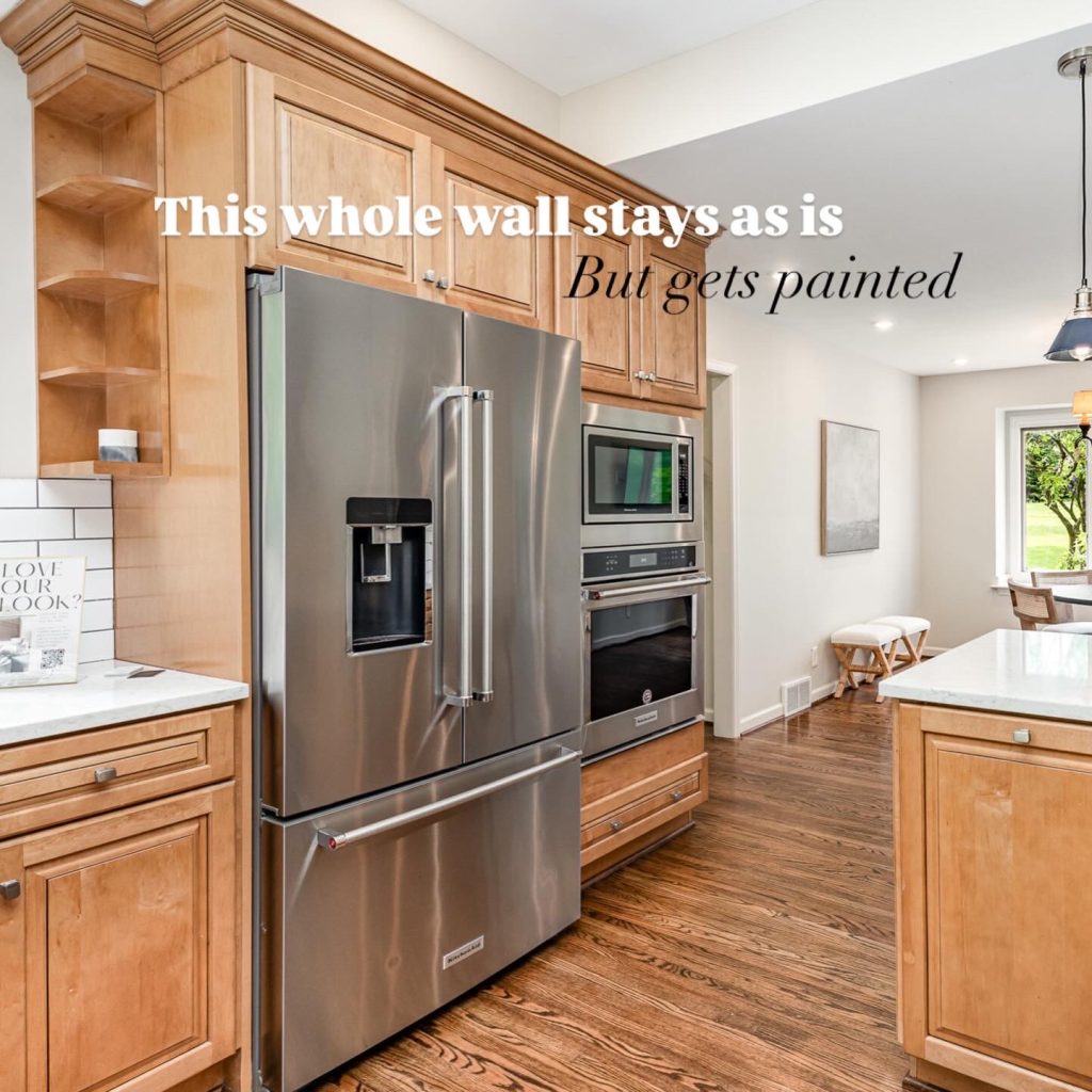 Original kitchen wall with full-height maple cabinetry, built-in stainless steel refrigerator, wall oven and microwave, shown before painting during a kitchen remodel by Meme Hill Studio